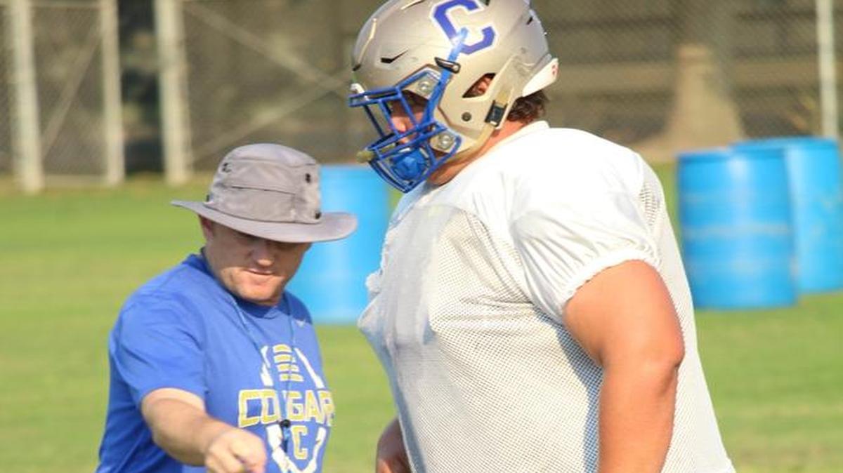 Rich Hammond, head football coach at Clovis High School, works with offensive lineman Kenny Blowers during a recent practice at Clovis High.