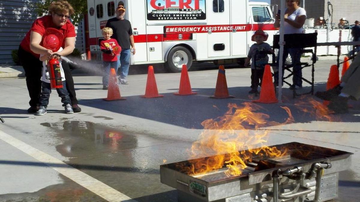 CERT volunteers show local residents how to use a fire extinguisher.