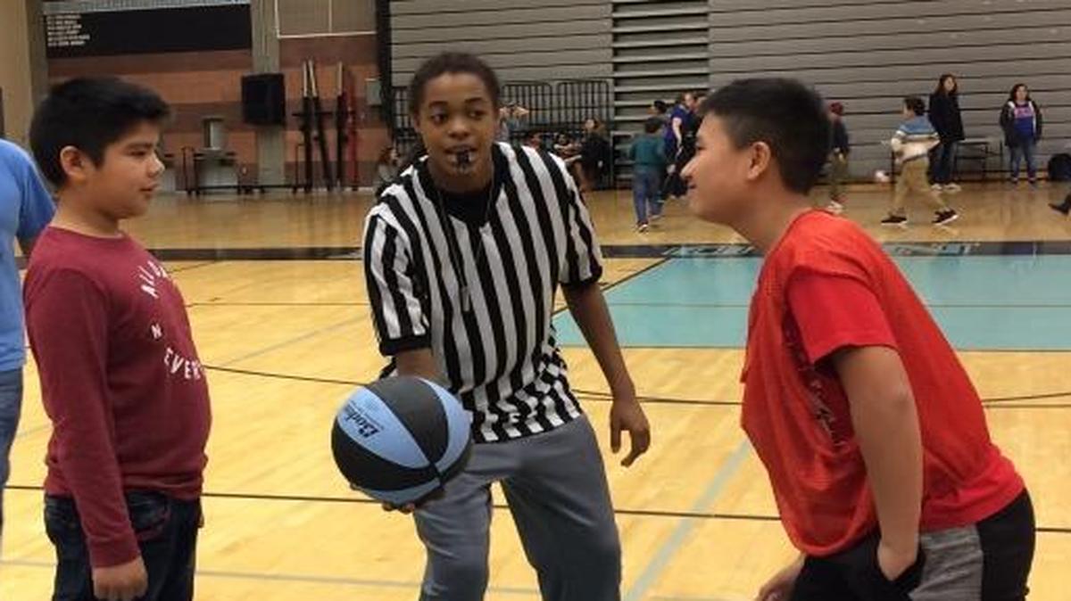 Joshua Bautista, left, and Brandon Moua, right, prepare for a jump ball thrown by Alyssa Roberson, a Clovis North senior varsity basketball player.