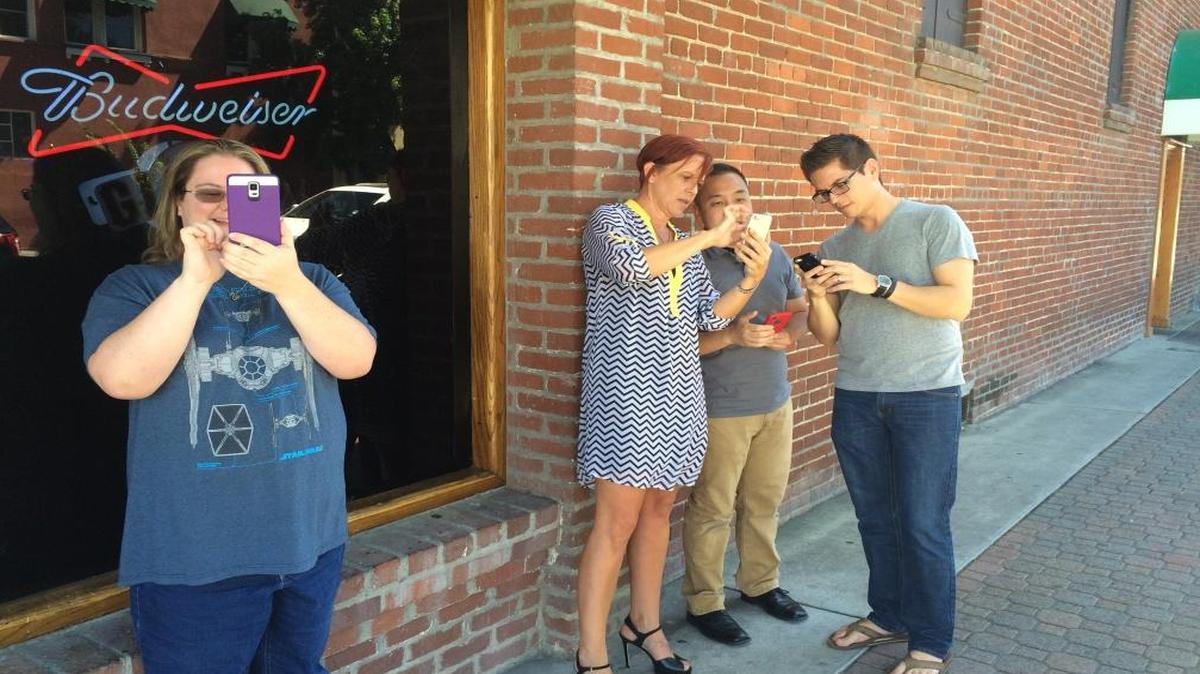 Jessica Holland, 38, Sheri Netto, 44, Thee Xiong, 26, and John Rios, 35, catch Pokémon near the 500 Club in Old Town Clovis.