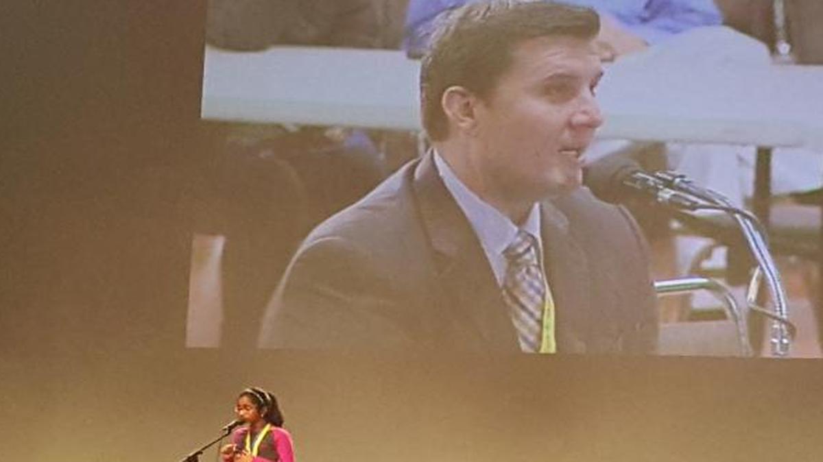 Fresno County Spell-Master Paul Loeffler, on the projector, congratulates Ananya Vinay, 11, on her Scripps Oral Spelling Bee win on March 15 in Fresno State’s Satellite Student Union.