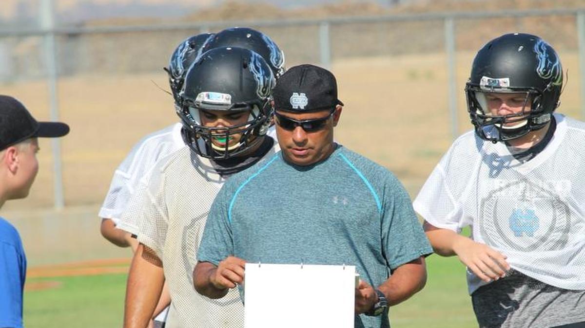Coach Casey Quinn checks on a play during practice at Clovis North High School.