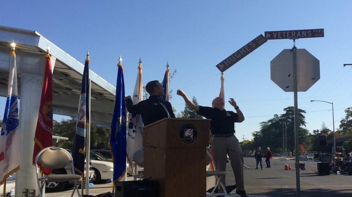Mayor Nathan Magsig, left, and Clovis Veterans Memorial District board chairman Tom Wright pull off the Hughes Avenue sign to unveil the new Veterans Parkway designation.