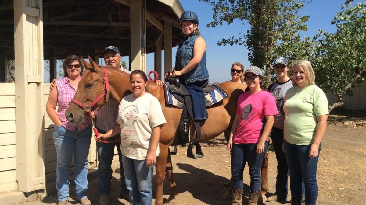
Guy and Carey Adams, left, and Megan McKeon, on therapy horse Bandit, surrounded by Heart of Horse Therapy Ranch volunteers. McKeon is missing her left leg due to severe burns as an infant. She has gone to ranch for therapeutic riding over over four years.
