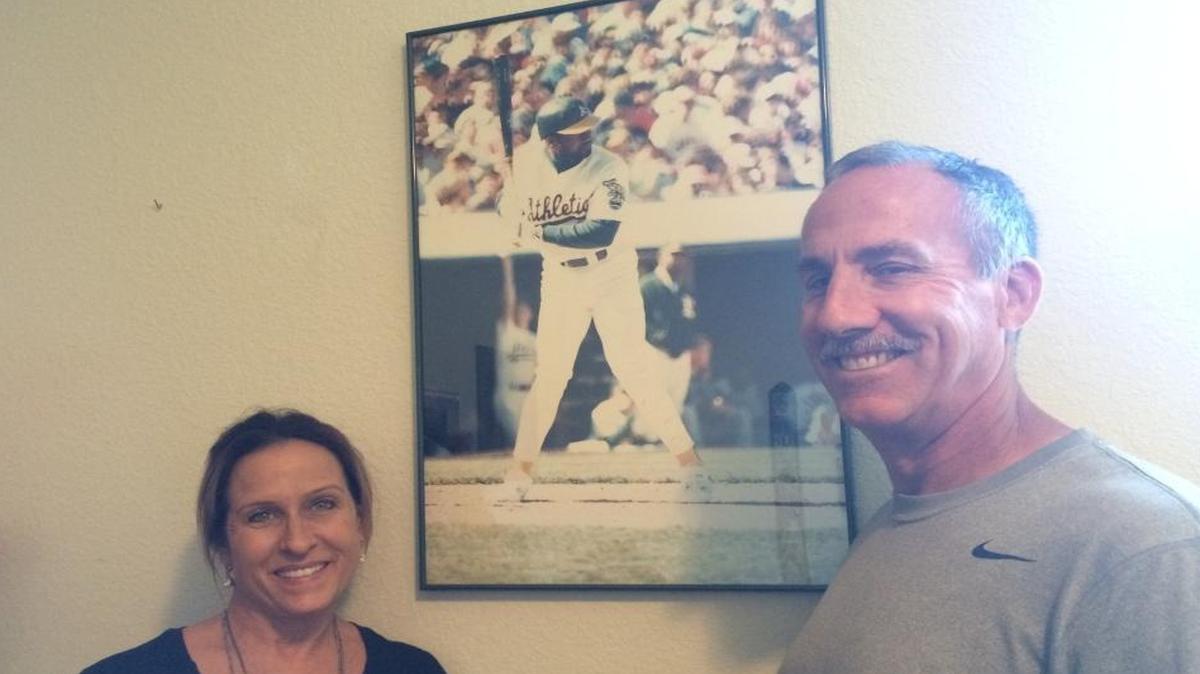 Sherri and Jack DuBeau stand near a photo of their friend, former MLB player Dave Henderson. Sherri donated a kidney to Henderson before his death from a heart attack.