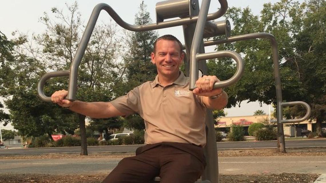 
Mayor Nathan Magsig demonstrates the use of a chest press machine, newly installed near the Clovis Old Town Trail just north of Gettysburg Avenue. 

