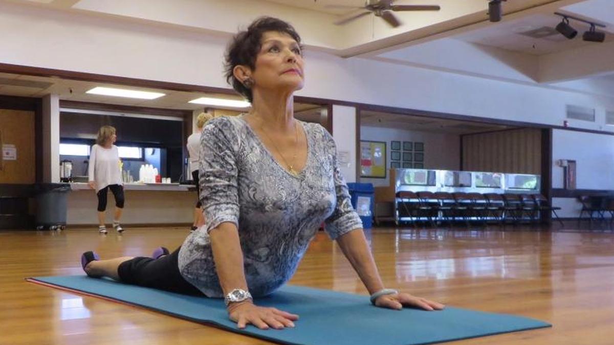 Eva Shanoian performs a cobra pose at her husband’s restorative yoga class in the Clovis Senior Activity Center.
