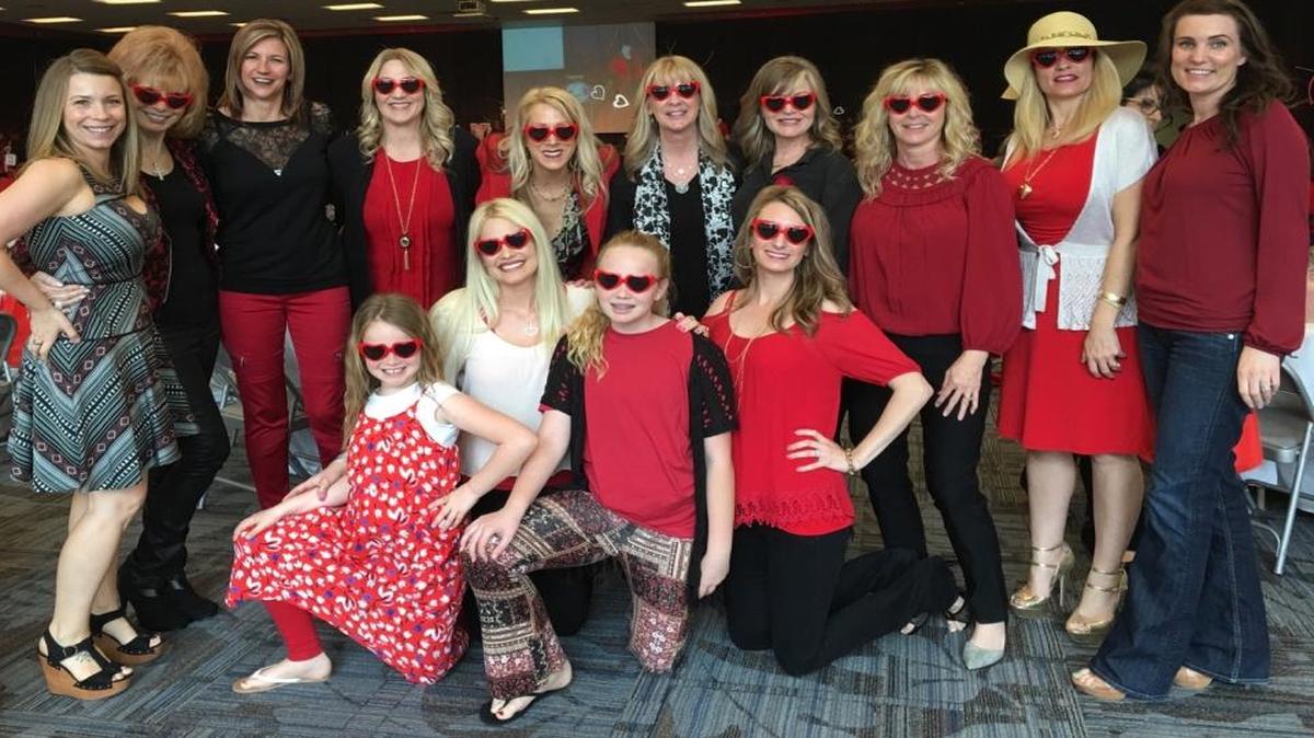 Melissa Tarlton, second from left in bottom row, is a 37-year-old stroke survivor. She is surrounded by her friends, family and E-Z Haul coworkers at the Go Red For Women event in Clovis Veterans Memorial District.
