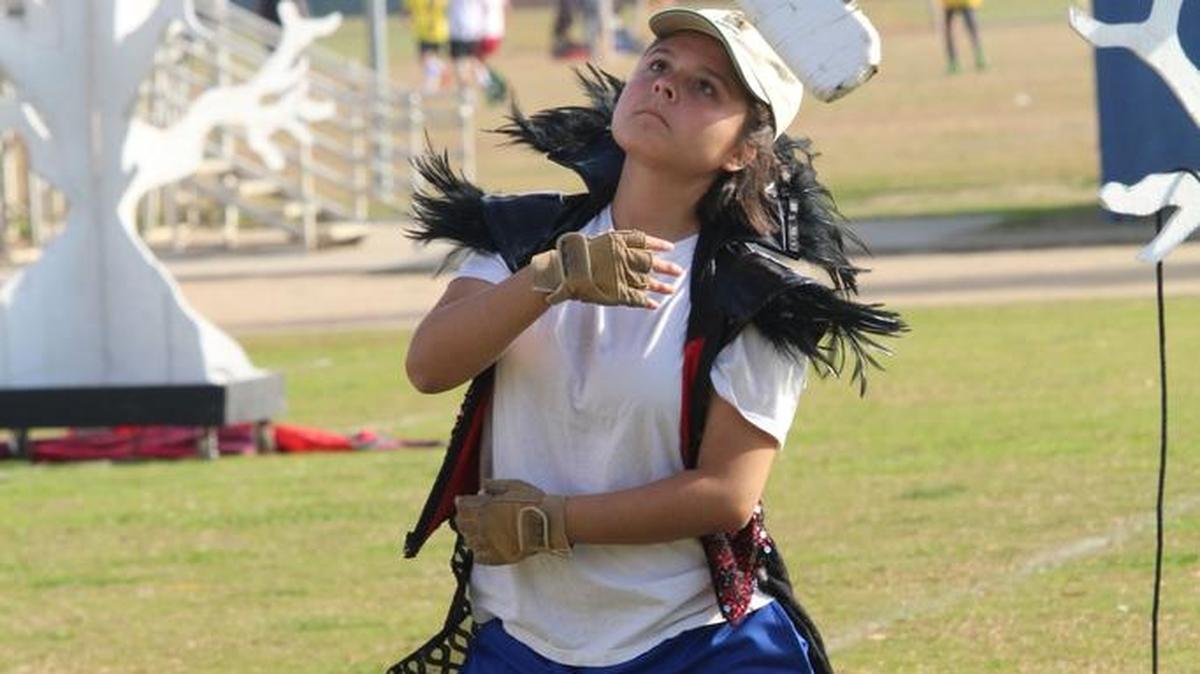 Micaela Araiza, a member of the Clovis High School Color Guard, practices a few hours before the band and color guard presented their competition show for the last time this fall. Araiza, a senior, wore part of her show costume during the practice.