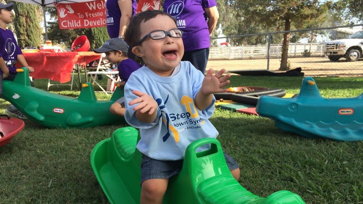 Isaiah Flores claps while rocking on a toy at last year’s Step Up For Down Syndrome event.