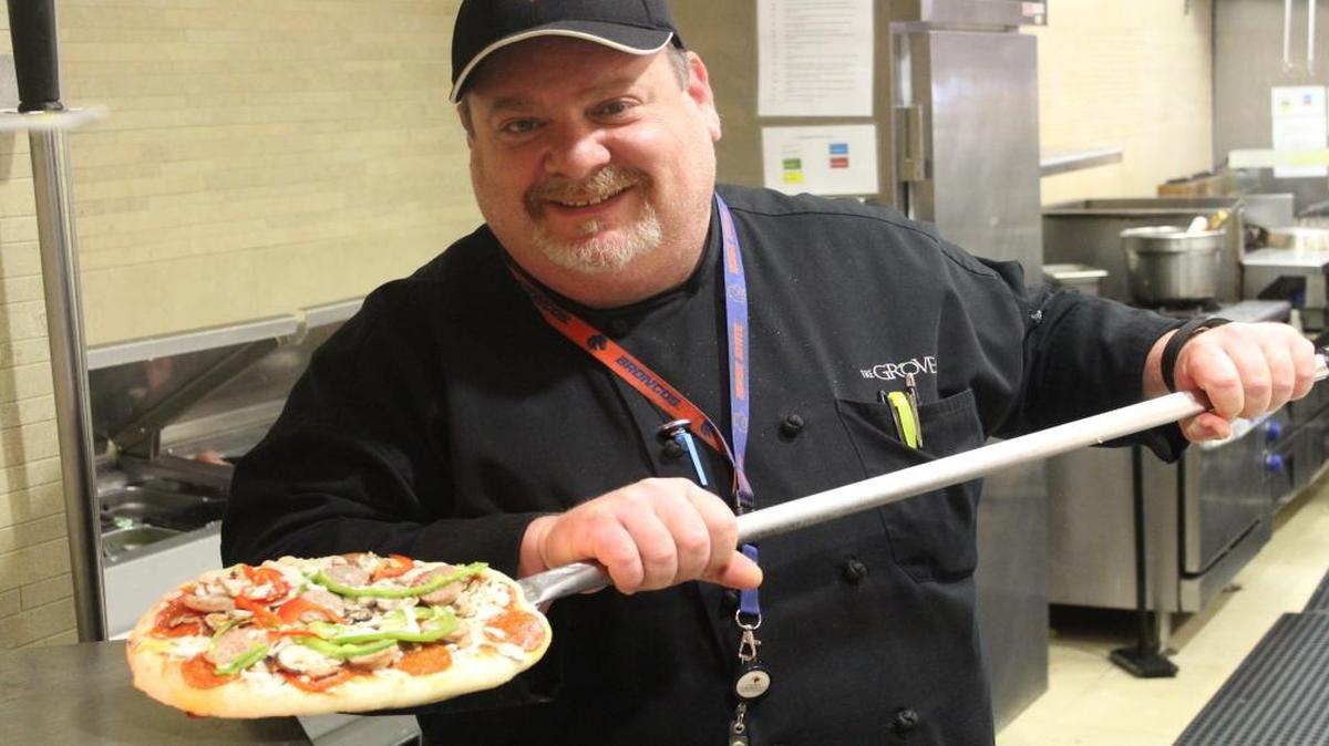 Jeff Dinmore, executive chef of nutrition and dining at Clovis Community Medical Center, takes a pizza from the the brick oven at the hospital’s Grove Cafe.