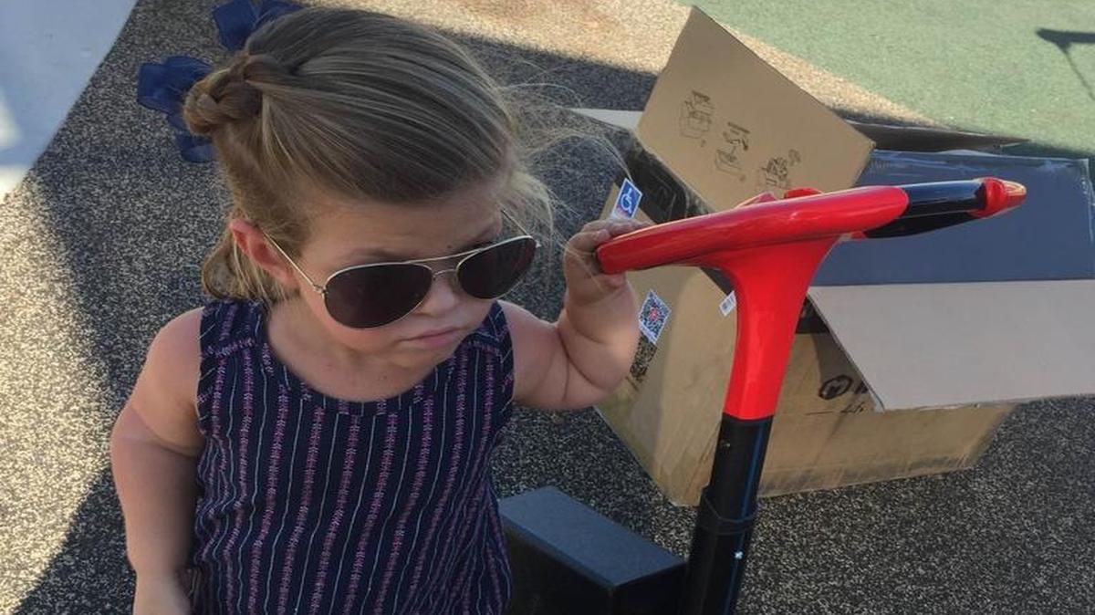 Payton Tumbiolo, 8, poses with her new Littlescoot mobility scooter.