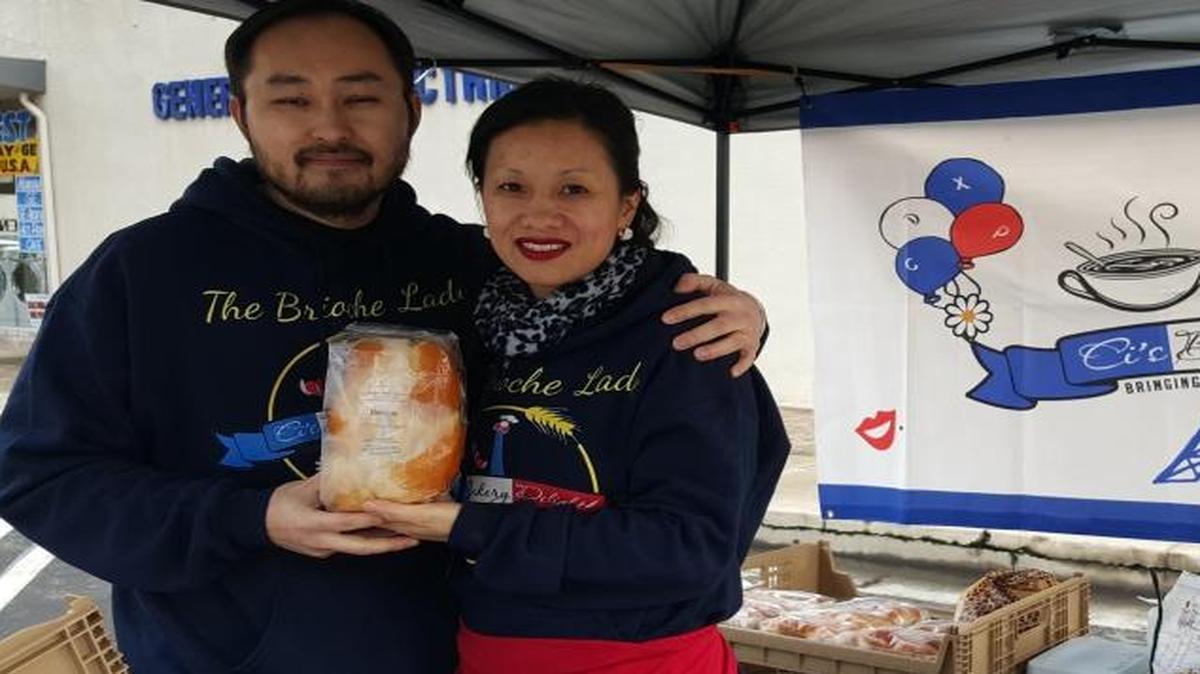 Leng and Nubchi Thao hold a loaf of French brioche in their booth at the farmers market. Nubchi, who was born and raised in France, started baking and selling plain and stuffed brioche after she was unable to find authentic varieties in the United States.