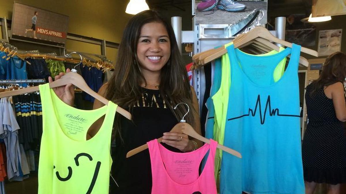 
Cruz shows off her best sellers, bright tank tops that say “run" in the shape of a smiley face. 
