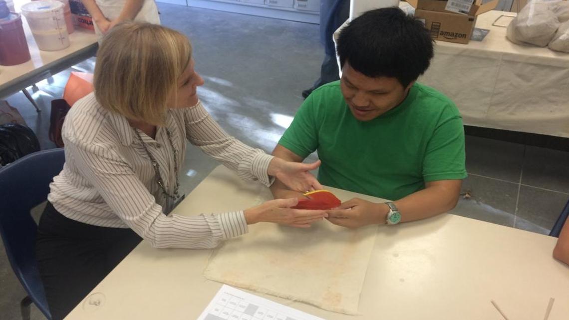 April Pair, a teacher for the visually impaired, explains a ceramics project to Clovis East student Cheng Xiong, who has been blind since birth.