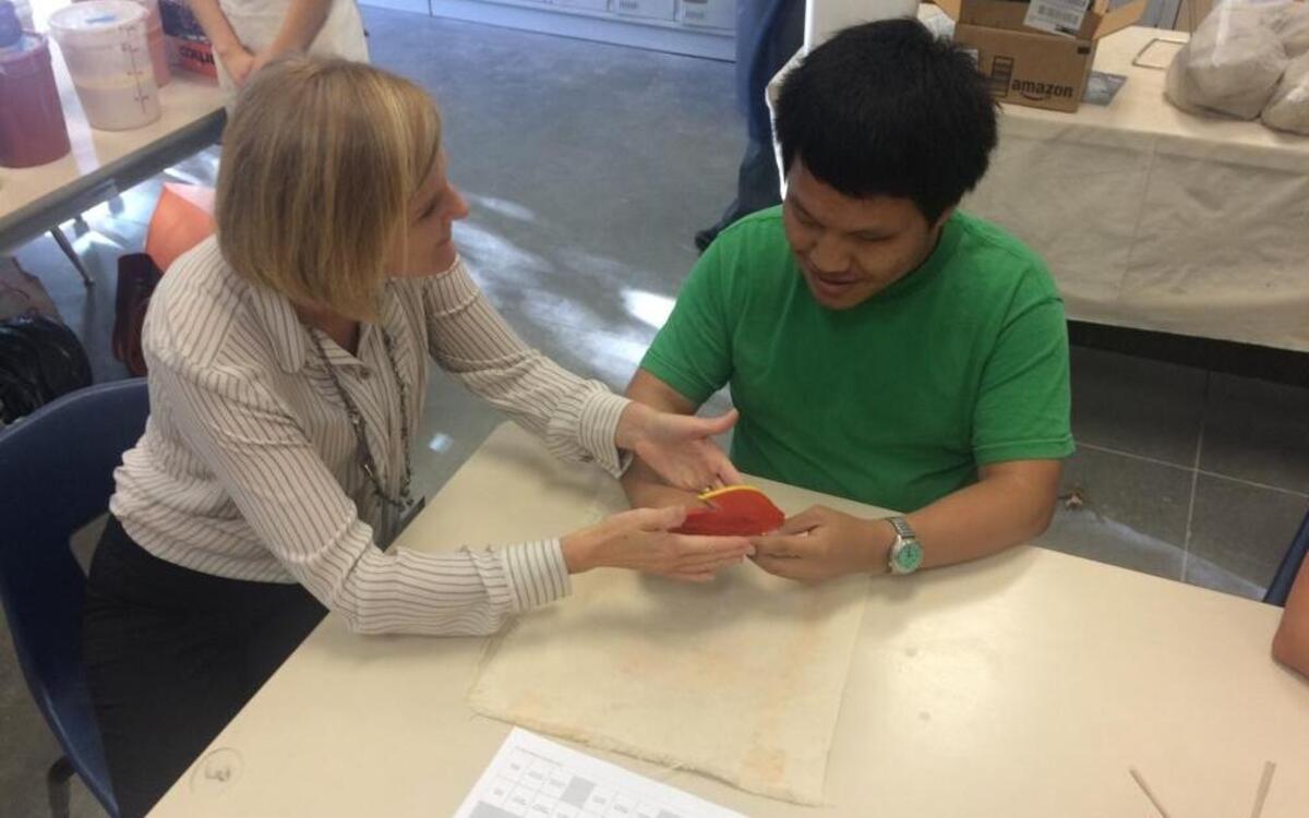 April Pair, a teacher for the visually impaired, explains a ceramics project to Clovis East student Cheng Xiong, who has been blind since birth.