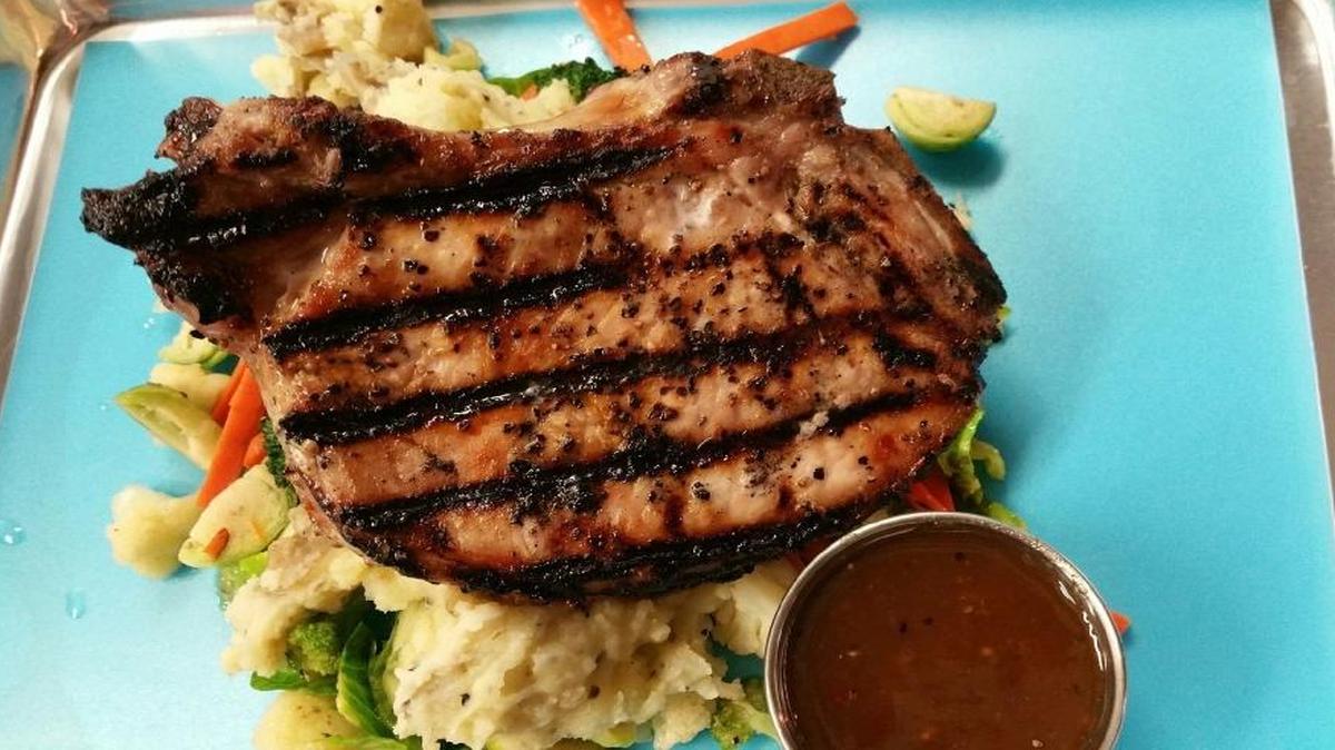 A grilled pork chop with rustic garlic mashed potatoes is one of the rotating entrees at Dukes, a new restaurant on Clovis Avenue.