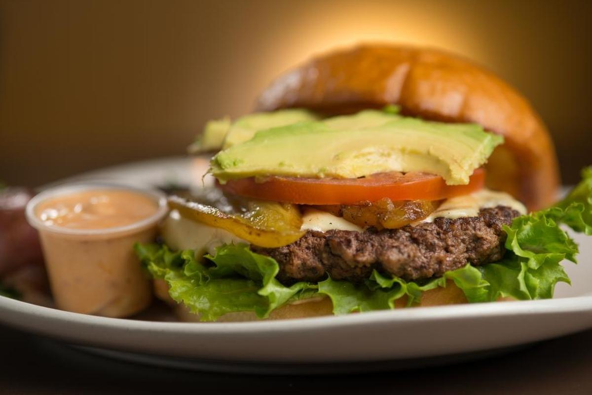 A signature Leticia Burger is made with pepper jack cheese, grilled Ortega chile, tomato, avocado, lettuce with a spicy chipotle cilantro sauce at both locations of House of JuJu in Clovis and Morro Bay, California.