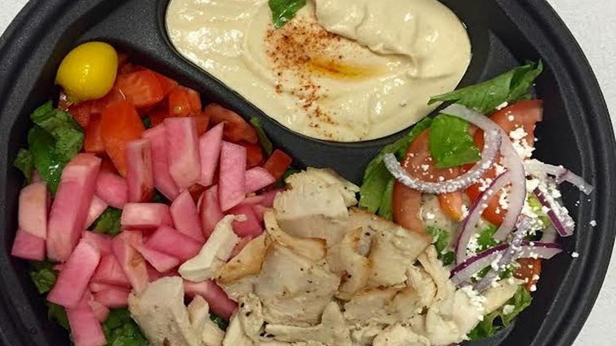 The chicken shawarma plate from The Broilers comes with hummus and rice pilaf (or hummus and salad), bright pink pickled turnips and a side of garlic sauce.