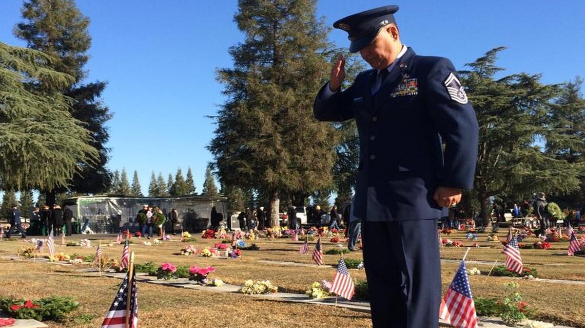 Air Force SMSgt. Art Cano, stationed with the 144th Fighter Wing of the Air National Guard, salutes the grave of a veteran.