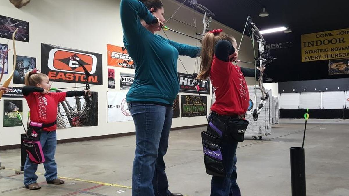 Baylee, 6, (left) and Lacee, 8, draw their bows alongside their mother, Melodie Polsgrove inside Impact Archery in Clovis. The girls have been shooting for nine months, while their mother took up the sport at the beginning of the year.