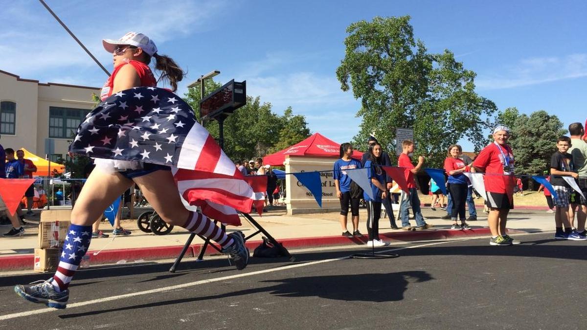 Pangia Xiong finishes the race holding an American flag.