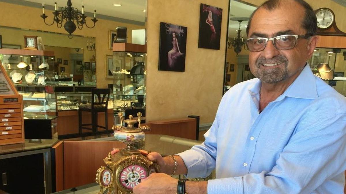 George Karkazian, owner of Karkazian Jewelers, admires a clock from 1860.