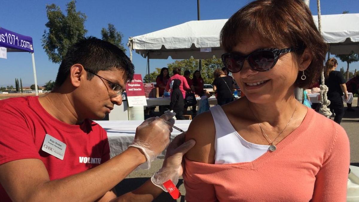 Raju Bashar administers a flu vaccination to Marylin Carter