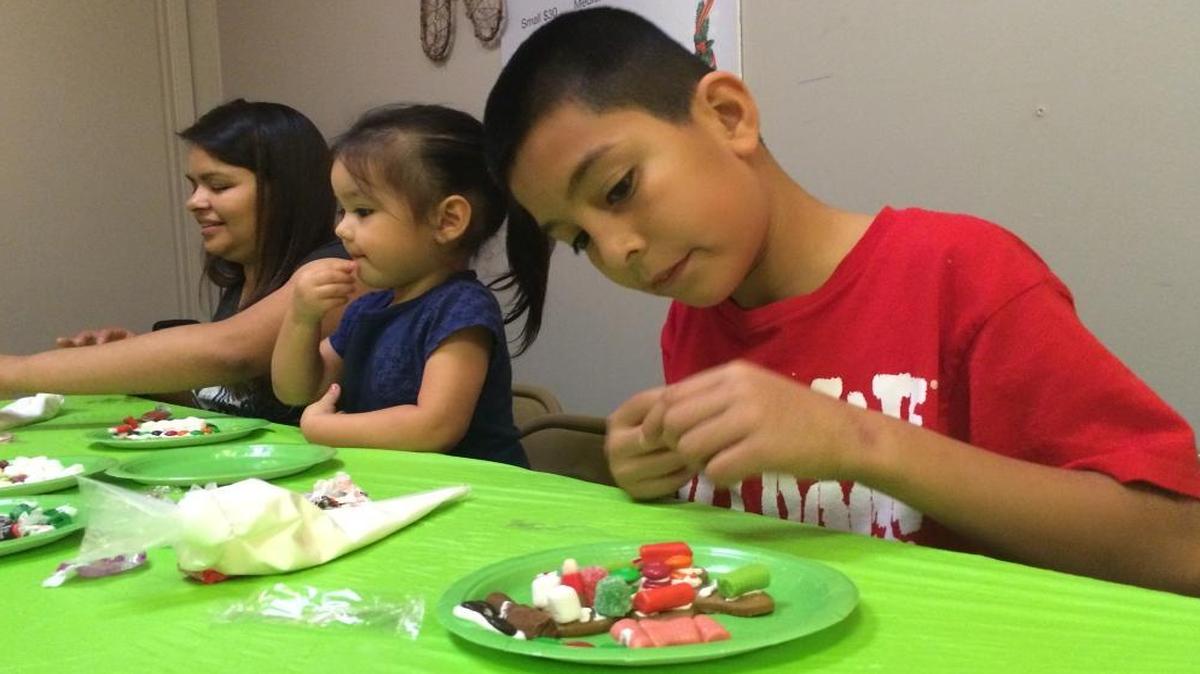 From left, Monique Garza, Madison Garza, 3, and Daniel Miramontes, 9, decorate gingerbread cookies inside Gingerbread Wonderland in Sierra Vista Mall.