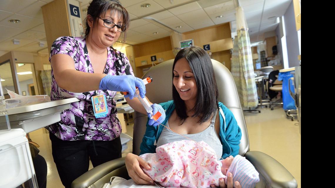 
 Nurse Monica Felix, left, helps Nitasha Rahman, 33, of Fresno, with a Gavage feeding tube for Rahman's daughter Kayla Rahman in the Neonatal Intensive Care Unit at Community Regional Medical Center in Fresno, California on April 24, 2015. Kayla was born about 7 weeks premature. 
