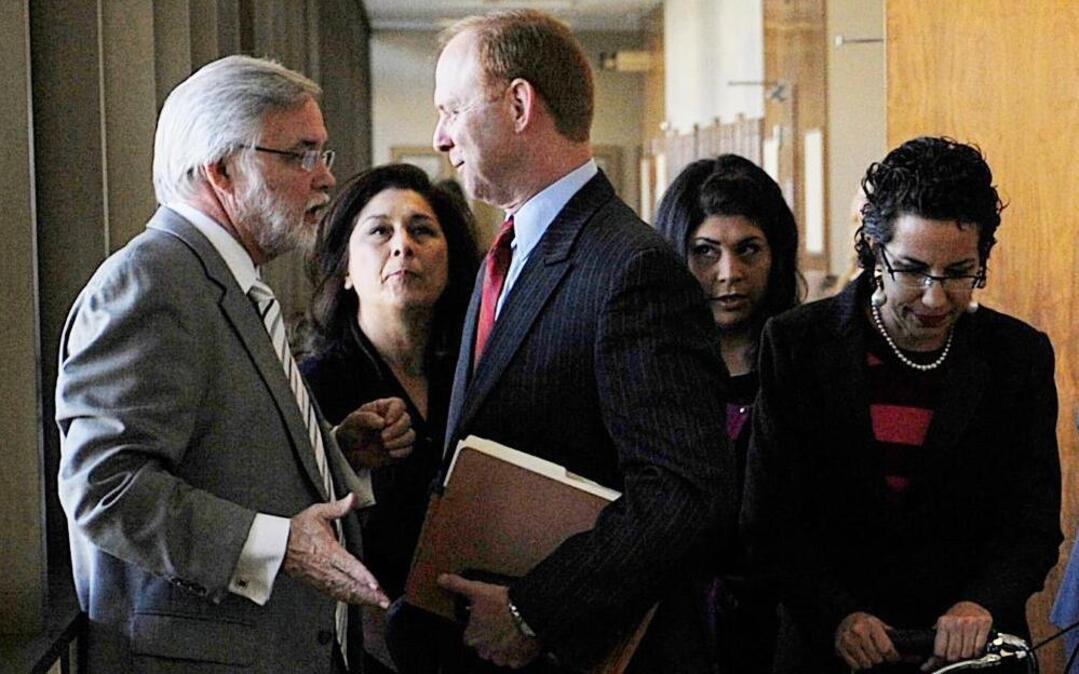 Attorney Marshall Hodgkins, left, talks to Kyle Scarber, as Gail Scarber stands in between them in the hallway outside of court.Their daughter Crystal Reynoso is shown following in this 2013 photo. The three are on trial for helping their son flee from justice during his rape case.