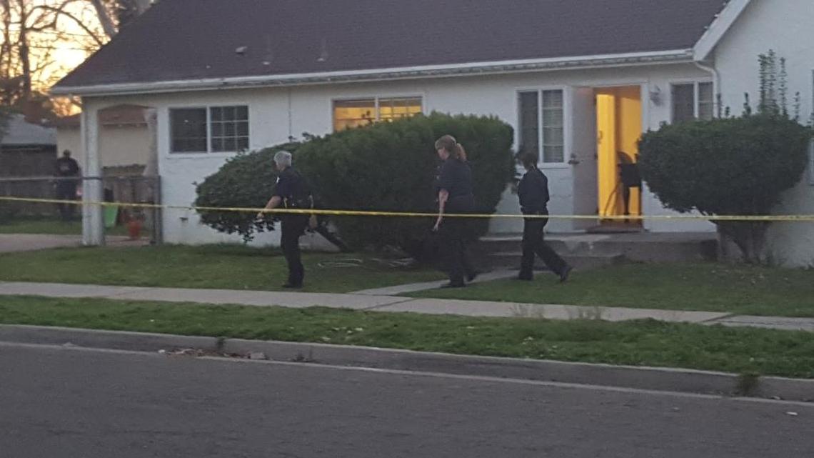 Police walk around a home hit by gunfire Monday during a drive-by shooting in southwest Fresno.