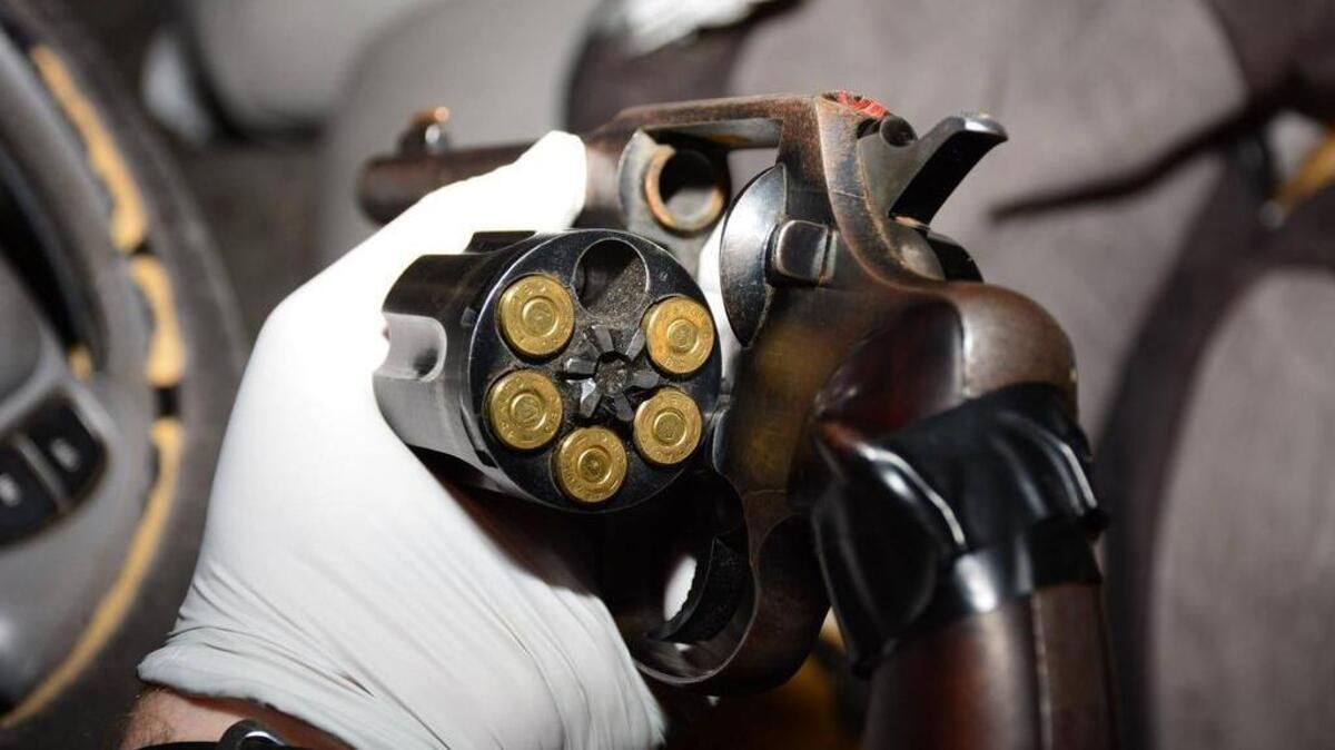 A .45 caliber handgun discovered in a car in northwest Fresno is examined by a police officer Saturday, April 29, 2017.