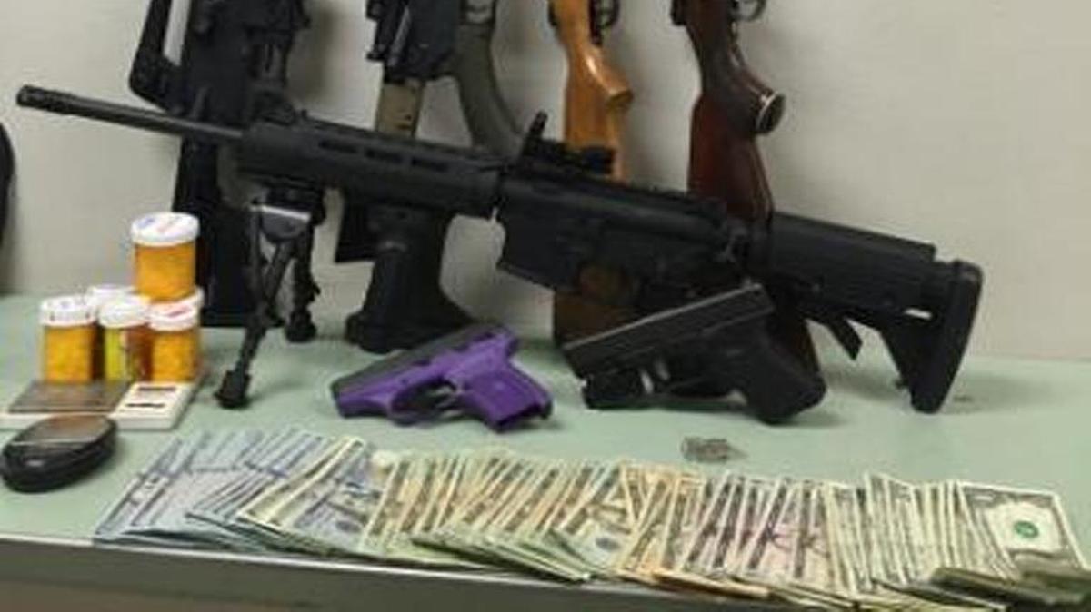 Weapons, drugs and cash seized from gang member by officers.