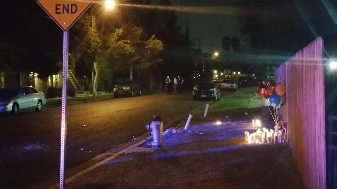 
Fresno police investigators gather on San Pablo Avenue just feet away from a memorial of candles and balloons set out in memory of two brothers who were gunned down on the street Thursday. Police were back out late Friday night for another shooting on the same street.
