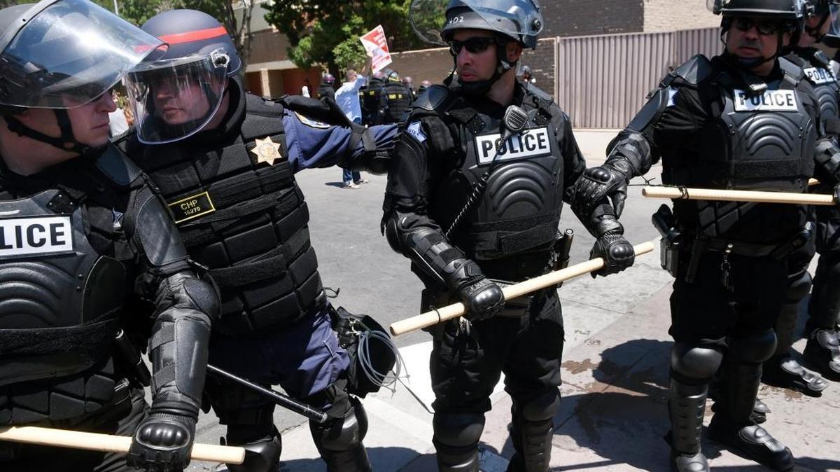 A California Highway Patrol officer, center, talks to a Fresno Police officer as law enforcement were deployed for protesters during the rally for presumptive GOP presidential nominee Donald Trump on May 27, 2016 in downtown Fresno.