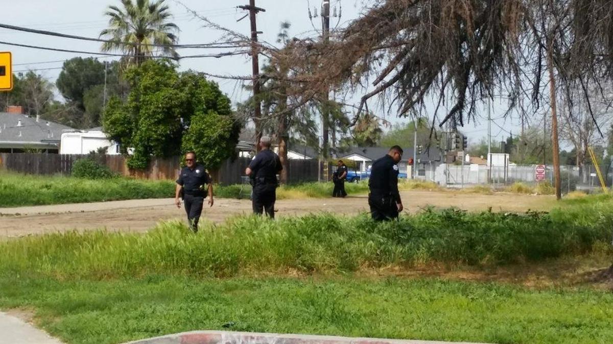 Fresno police search for clues Sunday in a dirt lot near Buckingham Way and Clark Street in central Fresno where a shooting was reported.