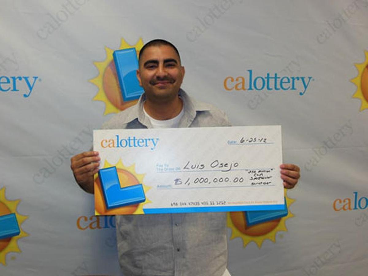 Luis Osejo poses for a photo in June 2012 with his oversized $1 million lottery winner’s check.