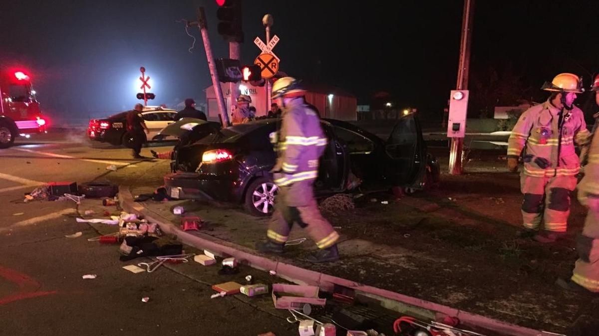 Visalia firefighters and police officers survey the damage after an allegedly DUI driver rolled her car across railroad tracks and into a traffic signal at Murray Avenue and Giddings Street.