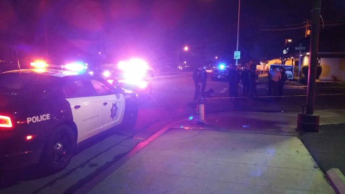 Officers stand at the scene of a shooting that left one man in critical condition in central Fresno on Wednesday.
