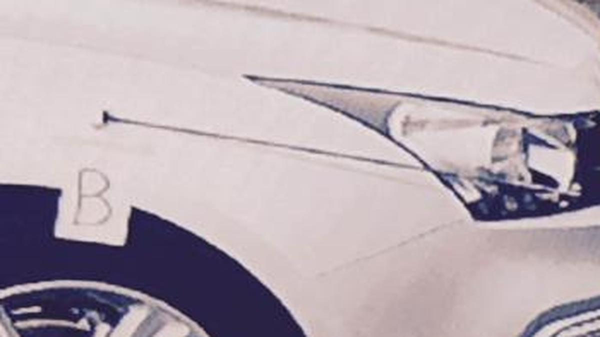 Marker indicates bullet hole in a car where a police officer took cover at the Fresno fairgrounds.