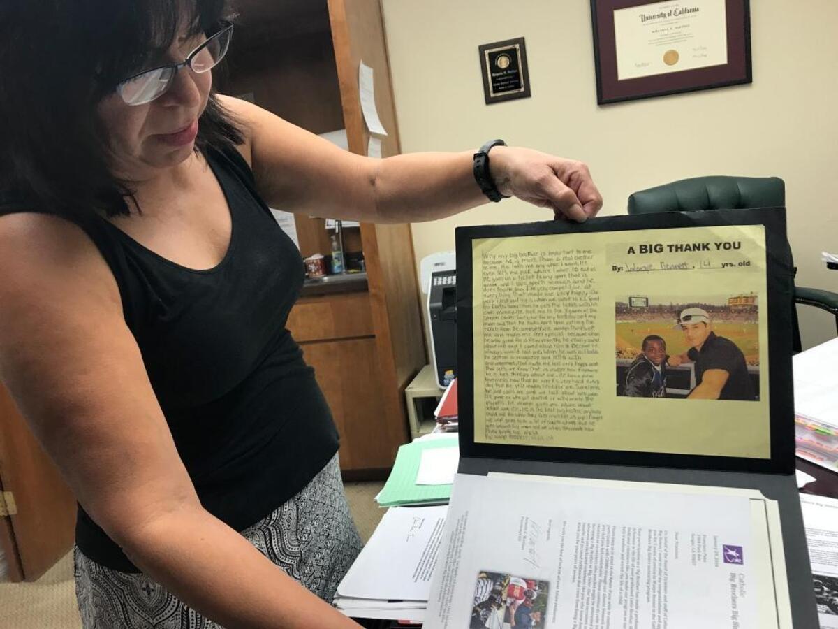 Fresno defense lawyer Margarita Martinez-Baly shows off a poster that was given to former Parlier High basketball coach Francisco Peña for five years of service to the Catholic Big Brothers Big Sisters mentoring program. Peña, 38, is accused of having unlawful sex with a minor.