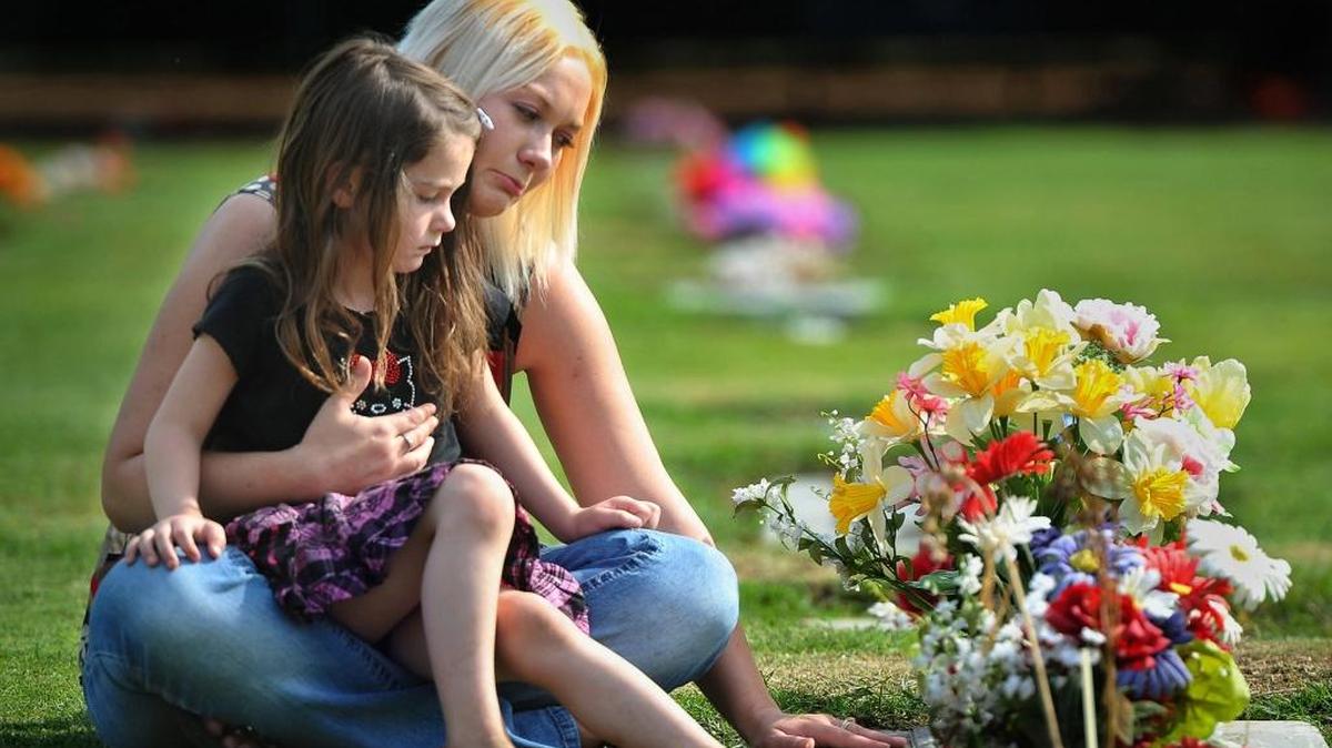 
Beth Bulmer and 5-year-old daughter Izzabella visit the grave of Rick Bulmer, Beth’s husband who was killed in 2008, at the Clovis Cemetery

