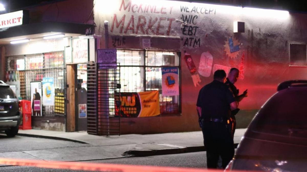 Police investigate at the scene of a shooting Sunday night outside McKinley Market in central Fresno.