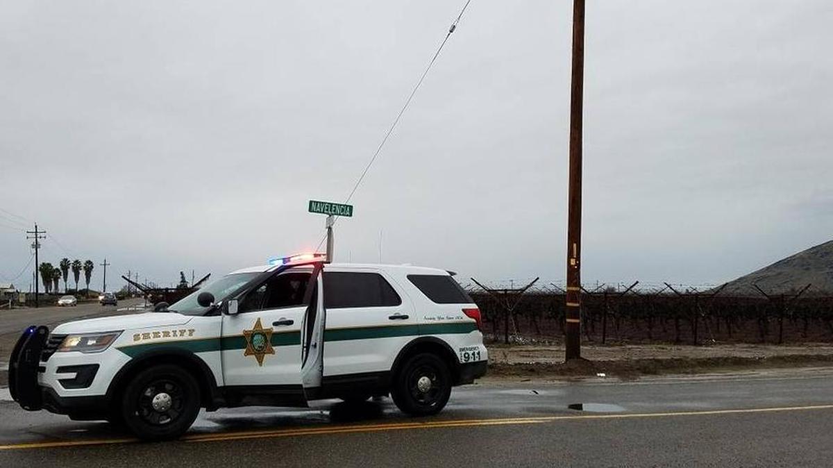 A Fresno County sheriff’s deputy blocks traffic on Navalencia Avenue near Reedley where a man’s body was found in a vineyard Saturday, Jan. 7, 2017.