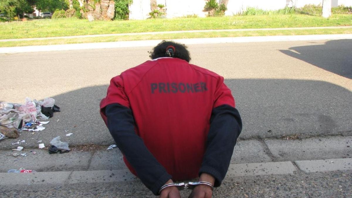 Issac McCoy sits handcuffed after he was detained Monday by Fresno County sheriff’s deputies.