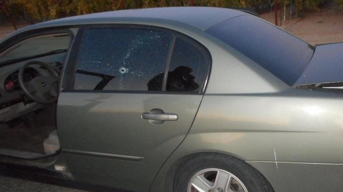 Damaged car with bullet hole.