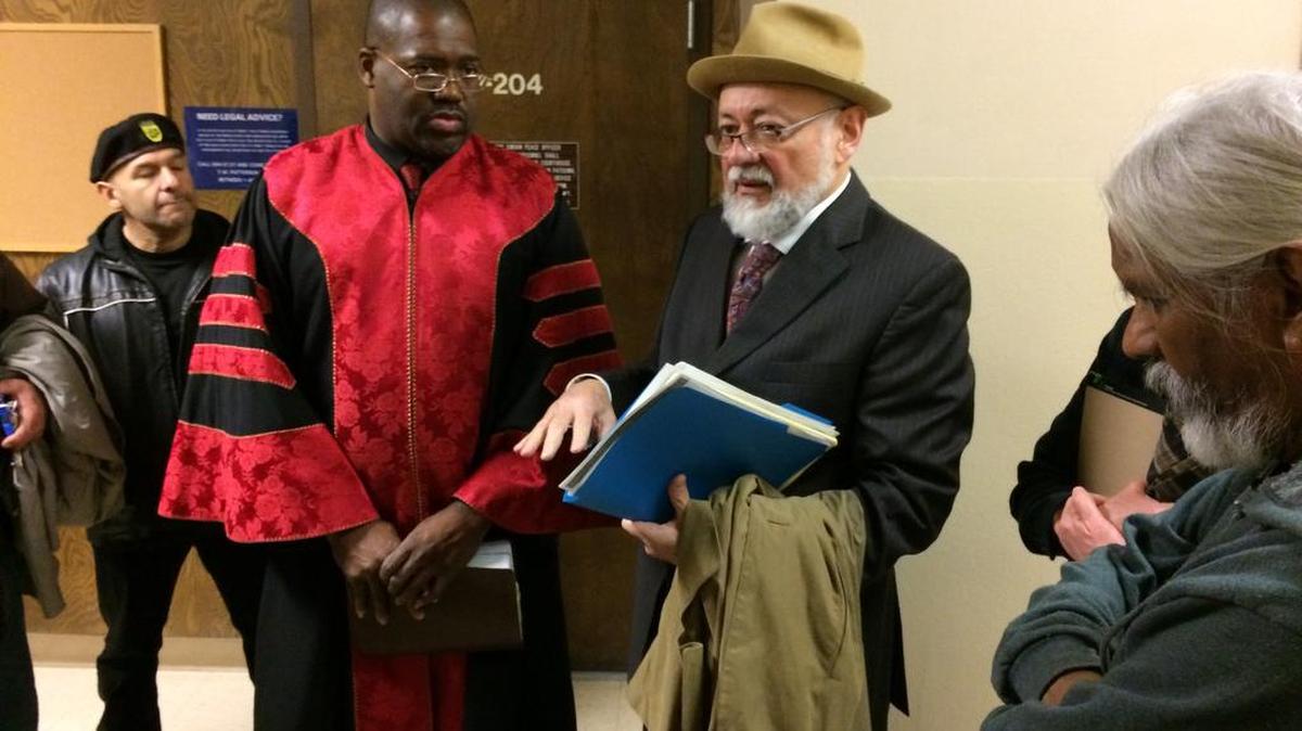 The Rev. Floyd Harris Jr., in a red robe, stands next to his attorney, Robert Navarro, after Harris pleaded not guilty Wednesday, Jan. 6, 2016, in Fresno County Superior Court to misdemeanor charges of obstructing traffic and participating or sponsoring an anti-police rally in downtown Fresno without a permit. About a dozen people went to court to support Harris.