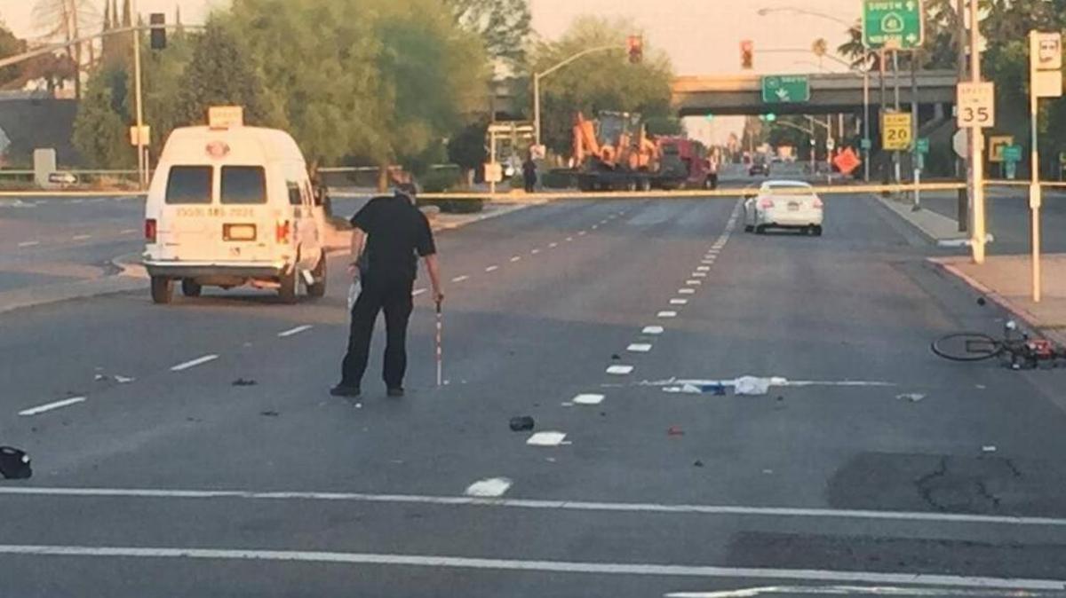 A police investigator works at the scene of a fatal collision between a medical van and a motorized bicycle on East Shields Avenue just west of North Fresno Street on Wednesday, June 21, 2017. The victim was identified Thursday as Matthew Paine, 32, of Fresno.