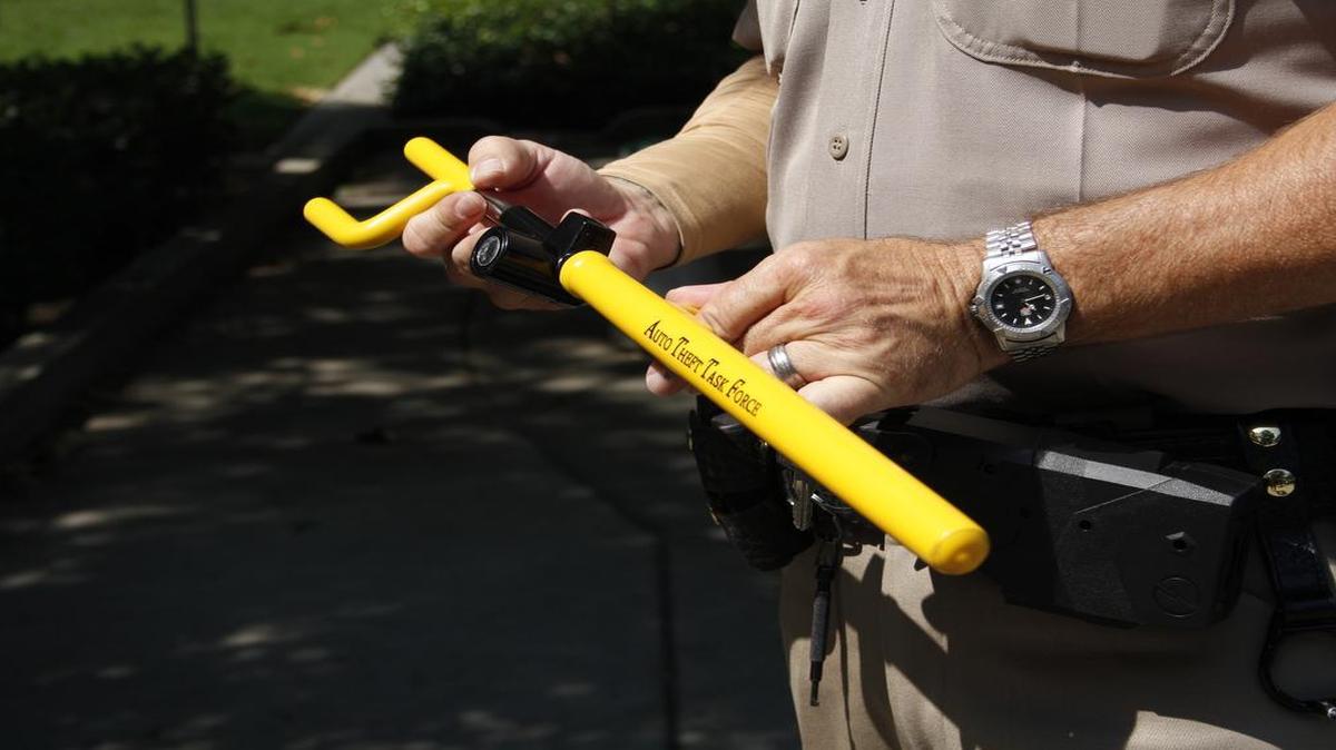 
A California Highway Patrol officer shows the “club” steering wheel lock device, which will be distributed on Saturday from 7-10 a.m. at the Cherry Auction in an effort to reduce the amount of stolen vehicles in Fresno County.
